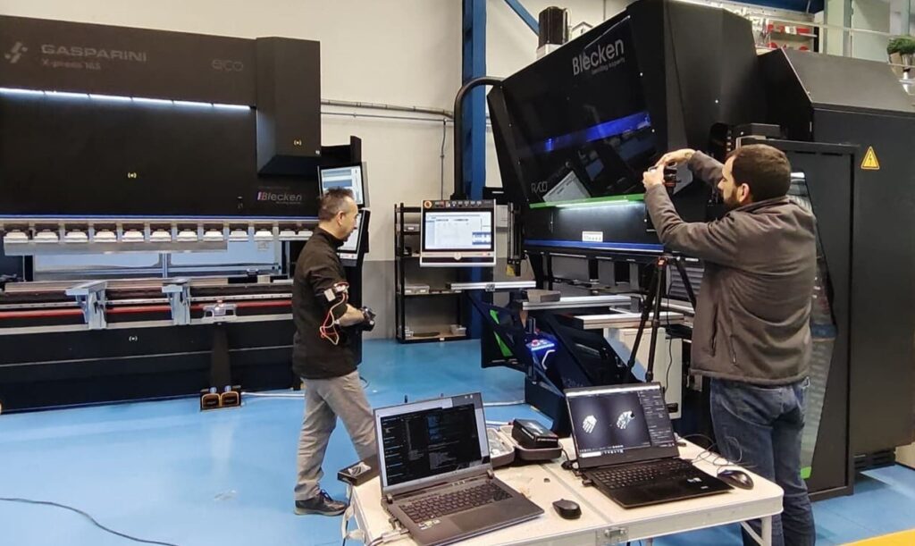 Técnicos de Blecken analizando datos de captura de movimientos en máquina plegadora industrial mientras software C-MOTRIZ procesa trayectorias para automatización robotizada sin código manual.